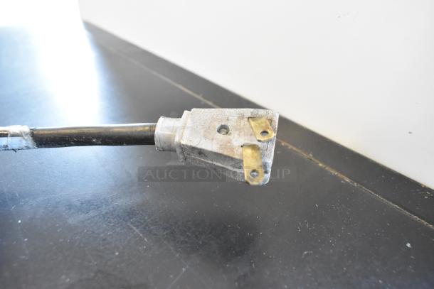 A frayed power cord with exposed wires for a True Commercial 2 Door Reach In Cooler Merchandiser, showing signs of wear.