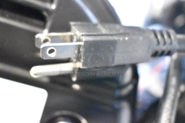 Close-up of a 115V power cord plug for the Sencotel Freazy 2 slushie machine, showing standard prongs.