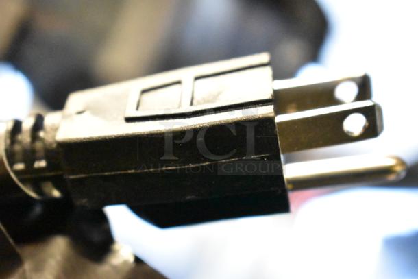 Close-up of a power plug for the Sencotel Freazy 3 slushie machine, highlighting the 115-volt compatibility.