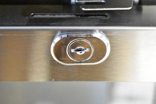Close-up of Avantco 178UBB72GHCS lock mechanism on stainless steel counter height back bar refrigerator.