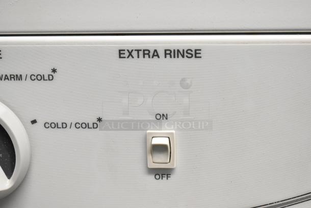 Speed Queen front load washer control panel with extra rinse switch, showing on and off settings.