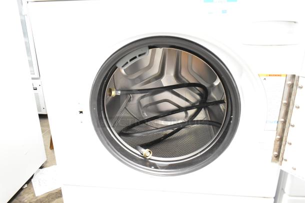 Speed Queen Alliance AFN50FSP111TW01 washer interior; includes hoses. Clean condition. Front load design.