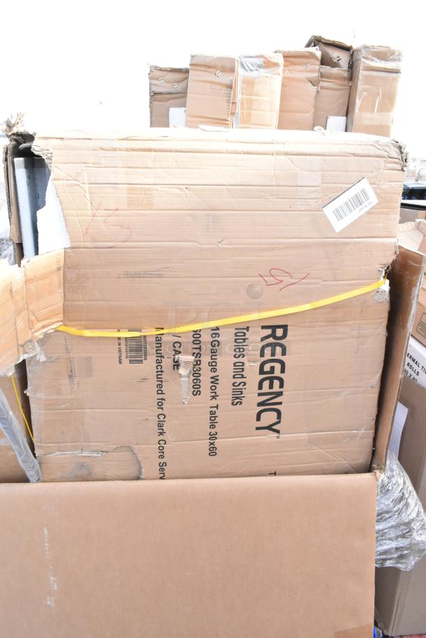 Cardboard boxes labeled "Regency Tables and Sinks" with visible scratches and dents, indicating the condition.