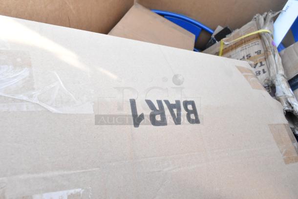 Cardboard box labeled "BAR1" in a lot of 13 scratch and dent items, including a blue chair, sinks, and pan racks.