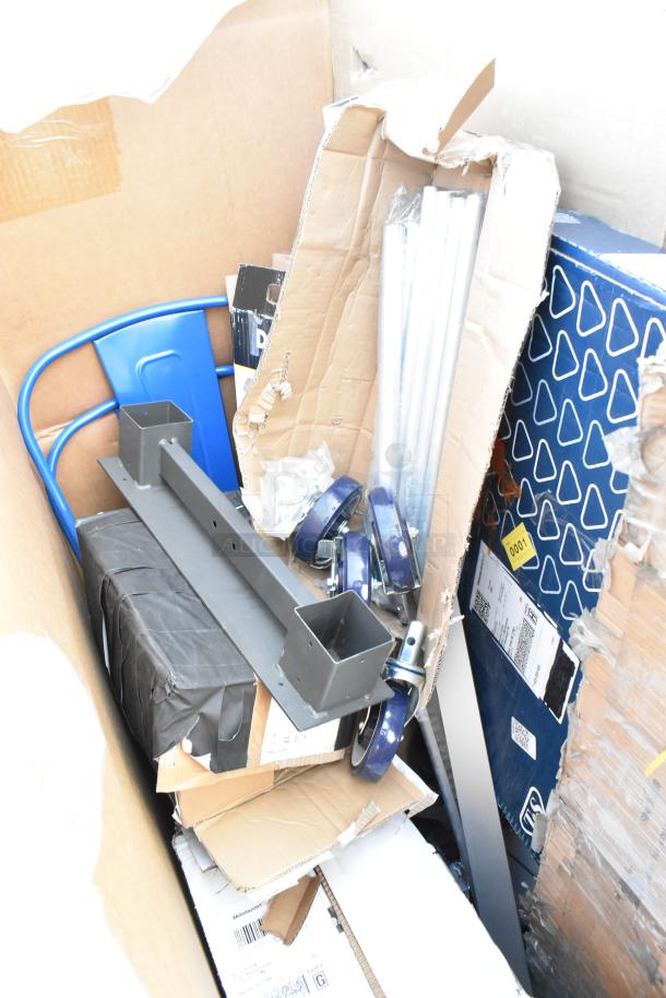 Auction items including a blue chair, metal pan racks, and caster wheels in a cardboard box. Scratch and dent condition.