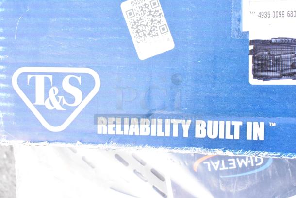 T&S box labeled "Reliability Built In," with a QR code and partial shipping labels visible on a blue background.