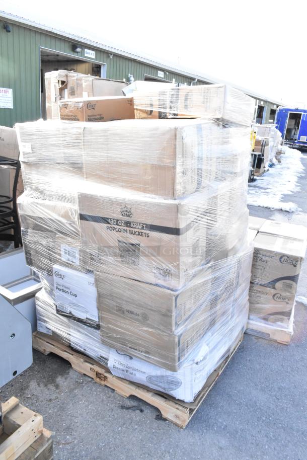 Pallet of new scratch and dent items including boxed paper towels, lids, containers, and gloves, wrapped in plastic.