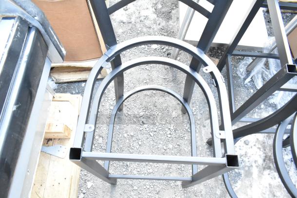6 new black metal cross-back bar chair frames with visible scratches and dents, sturdy construction.