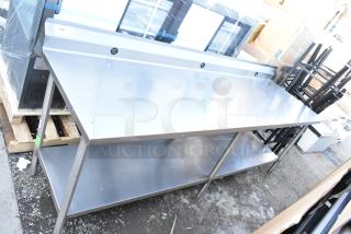 Stainless steel table with under shelf and backsplash, excellent condition, durable design, ideal for kitchen or workshop use.
