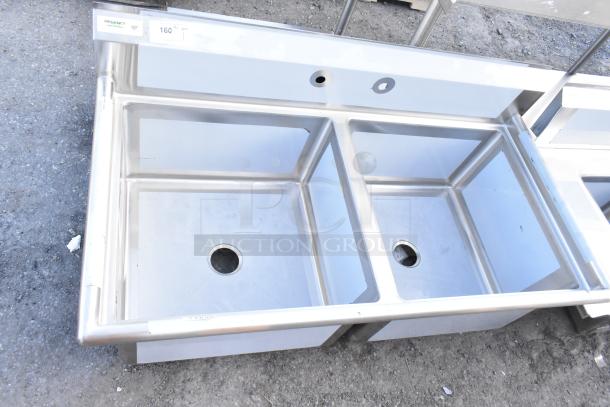 Brand new Regency 600S22424 stainless steel 2 bay sink; no legs, slight scratches noted; labels indicate NSF certified.