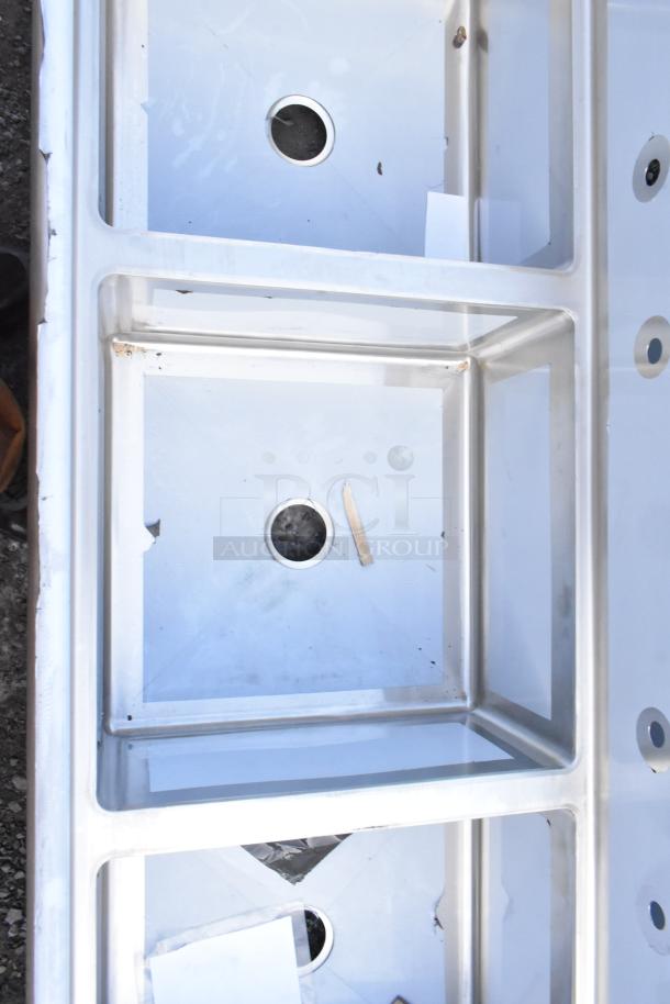 Brand new Regency 600S32323 three-compartment stainless steel sink, 16-gauge, with minor scratches and dents, no legs.