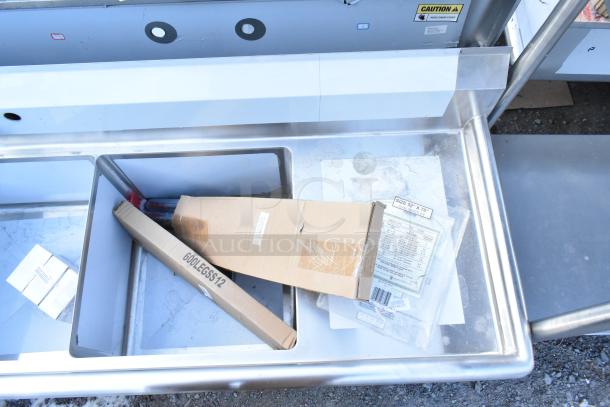 Brand new Steelton 522CS31818LR stainless steel 3 bay sink with dual drain boards, visible packaging and parts labels.