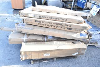 Stack of boxed items including Lancaster bi-fold tables, Steelton wire shelf, marked as new scratch and dent.