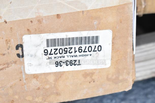 Cardboard box close-up showing a label with barcode and "4-High Wall Rack 36". Box contains new scratch and dent items.