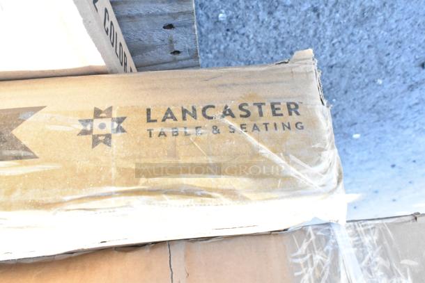 Cardboard box labeled "Lancaster Table & Seating," containing scratch and dent items including wire shelf and bi-fold tables.
