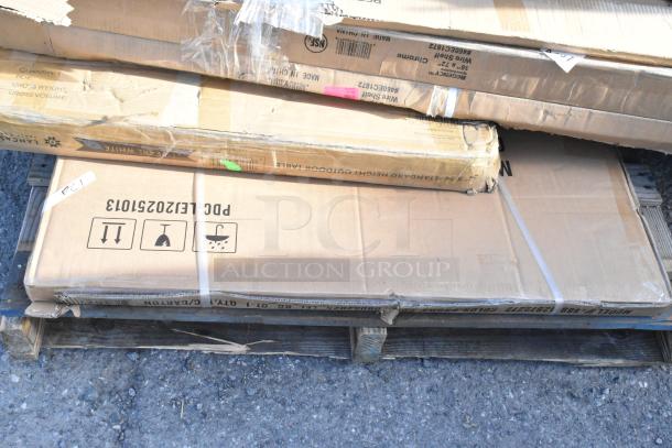 Image of shipping boxes on a pallet containing scratch and dent items, including a wire shelf and bi-fold tables. Labels indicate fragile content and handling instructions.