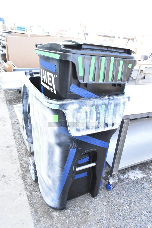 Two Lavex Pro black poly trash cans, new with visible scratches and dents, featuring handles and wheels, labeled "Lavex Pro."
