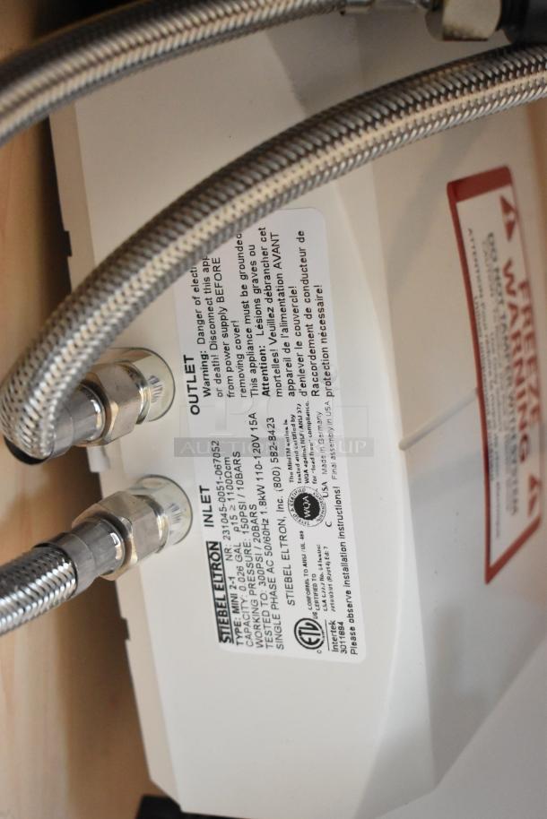 Alt text: Close-up of Ozark River Premier Maple Portable Sink label showing inlet/outlet connections and safety information.