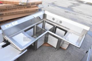 Brand new Regency 600S3141414C stainless steel L-shaped 3-bay sink with dual drain boards, minor scratches, no legs.