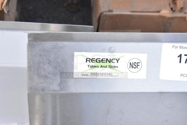 Regency 600S3141414C stainless steel L-shaped 3-bay sink with dual drain boards, scratch and dent, no legs. Model label shown.