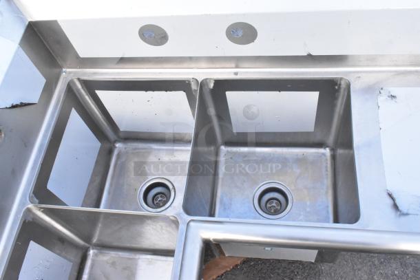 Brand new Regency 600S3141414C stainless steel L-shaped 3 bay sink with dual drain boards, scratch and dent, no legs.