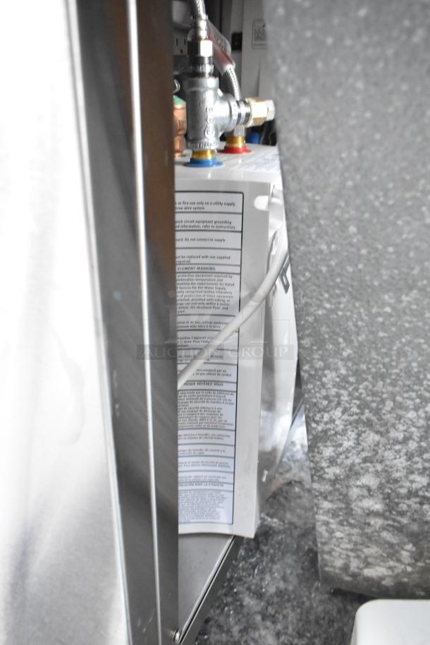 QualServ stainless steel single bay portable sink with commercial casters, visible plumbing, and attached manufacturer's label.