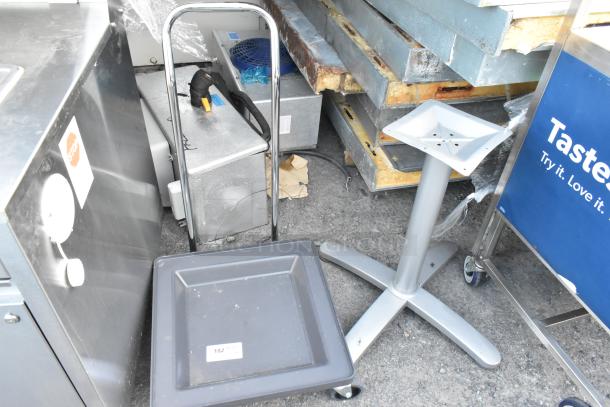 Dish caddy dolly with wheels and metal table base displayed. Dolly has a label "182." Both items show light wear.
