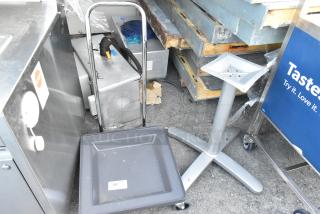 Dish caddy dolly with wheels and metal table base displayed. Dolly has a label "182." Both items show light wear.