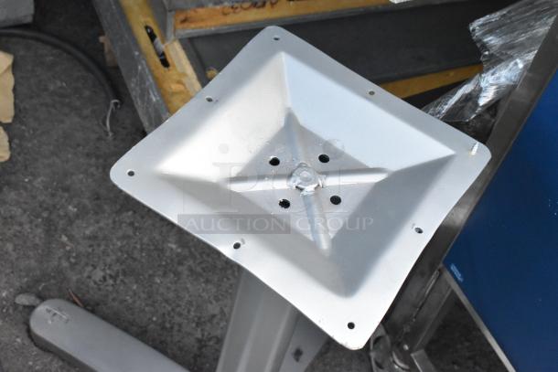 Metal table base with square top, pre-drilled holes for mounting, in used condition. Sturdy and industrial design.