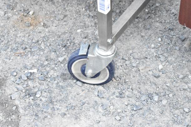 Stainless steel commercial caster wheel on National Cart Co table, showing durability and mobility.