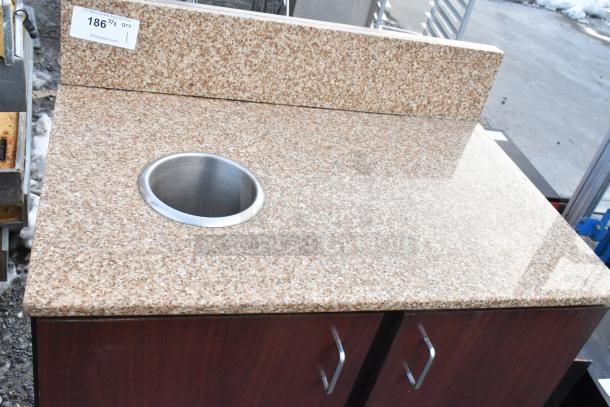 Wood pattern 2-door trash can shell with speckled countertop, featuring a stainless steel trash deposit hole, in good condition.