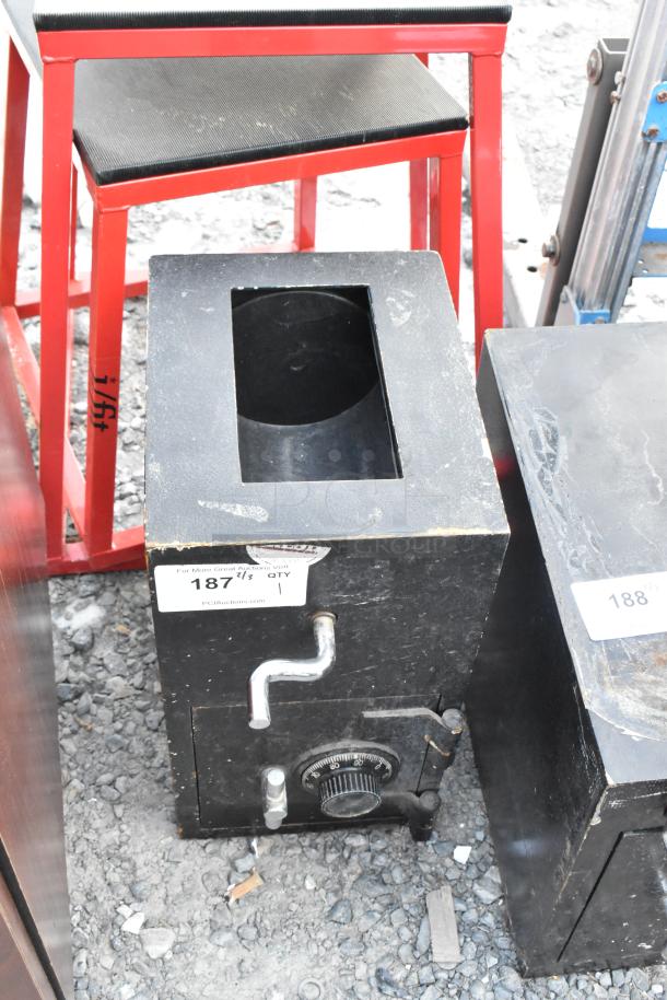 Black metal single compartment safe with a combination dial on the front; no combination included. Item tag labeled "187".