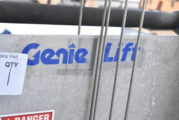 Genie Lift hand-operated lift truck, silver metal with visible logo and safety label, wires in front.
