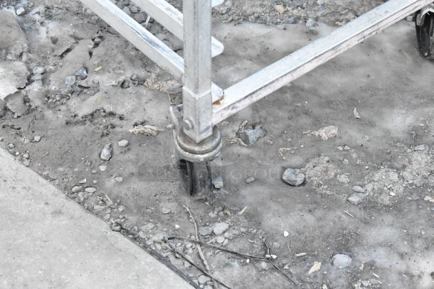 Commercial pan transport rack with metal frame on sturdy commercial casters, used condition, suitable for industrial kitchens.