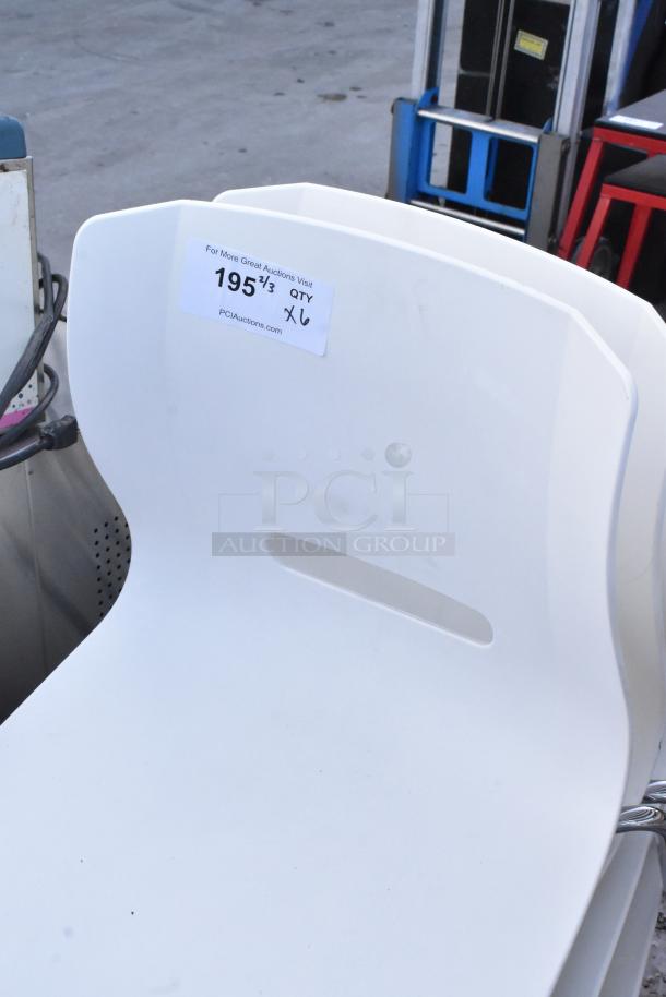 6 white poly chairs with chrome legs, modern design. Good condition. Label indicates auction details and quantity.