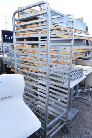 Commercial pan transport rack with multiple shelves on durable casters, in used condition. Ideal for bakery or catering use.