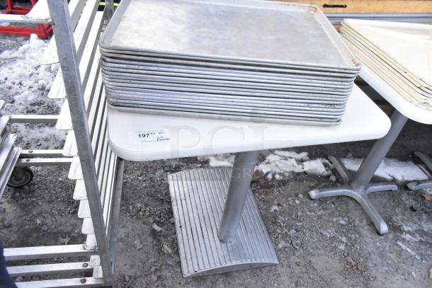 Three white dining height tables with stack of metal baking pans and white poly lids. Label reads "197 3X."