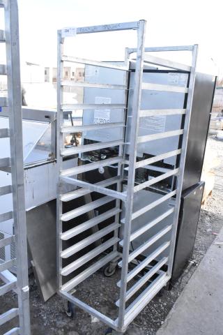 Commercial pan transport rack with multiple shelves, on durable commercial casters. Visible in used condition.