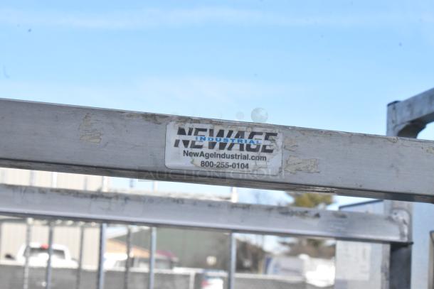 NewAge Industrial commercial pan transport rack with casters, showing brand label with website and phone number.