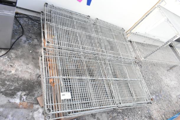 Lot of 8 chrome finish wire shelves, stacked on a pallet. Includes visible tag reading "206 Qty 8." Suitable for storage.