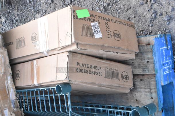 Cardboard boxes labeled "Element Stand Cutting Board" and "Plate Shelf" with model numbers 600ESWCB36 and 600ESCBPS36, NSF marked, placed on a pallet.