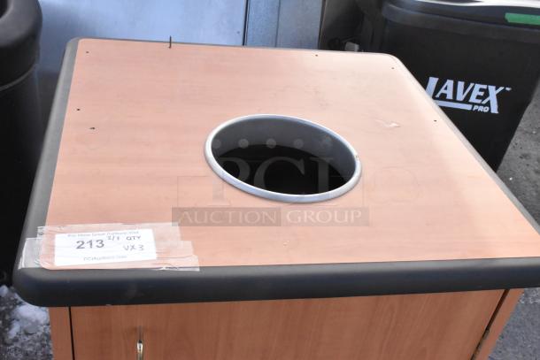 Wooden trash can shell with opening, includes two black Lavex Pro trash cans. Label reads "213, 3 times your bid".