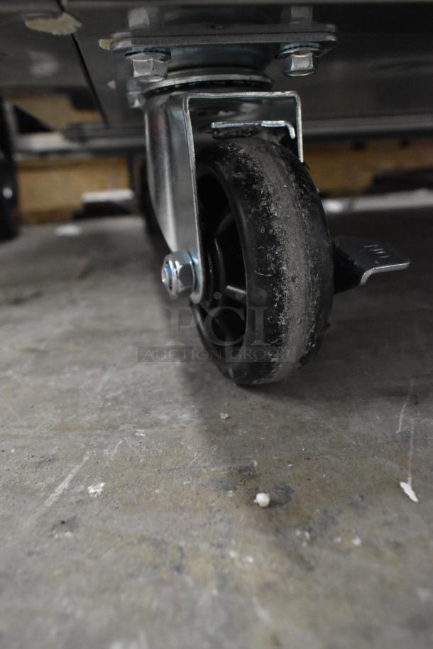 Close-up of a commercial caster wheel from the 2025 Mainstreet 829PT72 sandwich prep table, showing slight wear and dust.