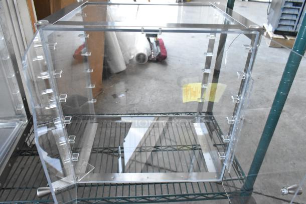 New clear poly countertop cabinet with scratch and dent; visible yellow tag; aluminum frame and shelves.