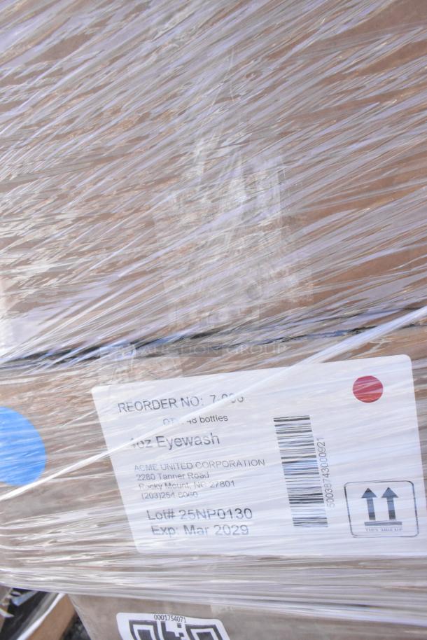 Pallet of assorted scratch and dent items wrapped in plastic, featuring labels indicating eyewash bottles, reorder number, and expiration date.