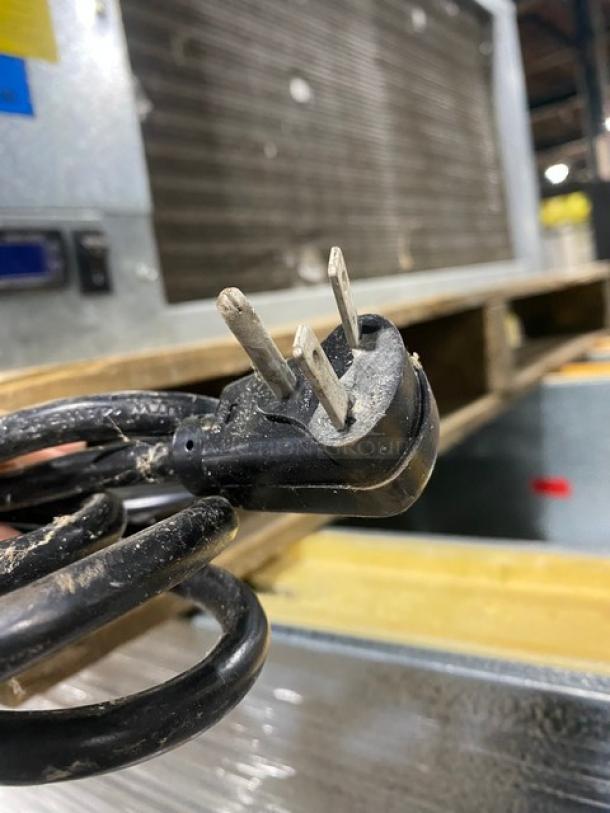 Three-prong power cord with visible dust, showing wear and signs of use, suitable for industrial equipment or appliances.