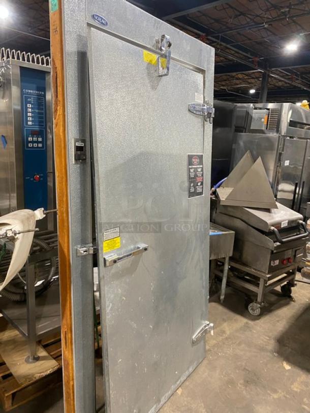 Walk-in cooler door, stainless steel, used condition. Visible locks and hinges; tags display model and safety information.