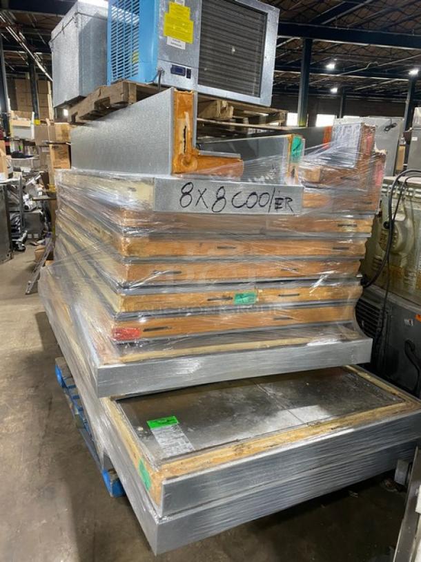 Stack of 8x8 cooler panels, wrapped and labeled, in warehouse. Includes metal and insulation materials. Used condition.