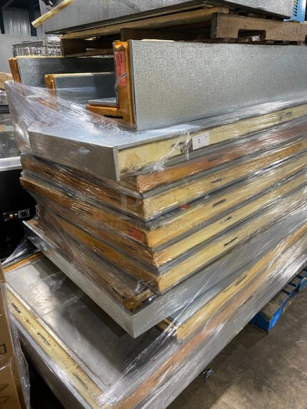 Stack of insulated metal panels wrapped in plastic, showing wear. Label marked with "2" indicating set number.