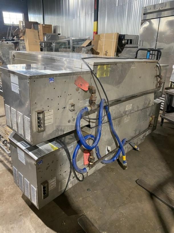 Commercial double-stack conveyor pizza oven, stainless steel, used condition, with attached blue hoses and visible tags.